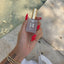 Noles 14 Eau de Parfum Travelsize in Hand mit Brunnen im Hintergrund