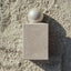 Fari Islands Eau de Parfum auf dem Strandboden bedeckt mit etwas Sand